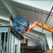 A fork lift lifts a cherry picker to the top of the mezzanine.